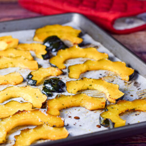 Sliced acorn squash on a jelly roll pan straight out of the oven - square
