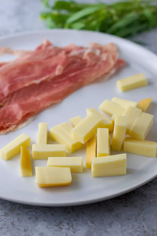 Gouda slices, prosciutto and tarragon in the background