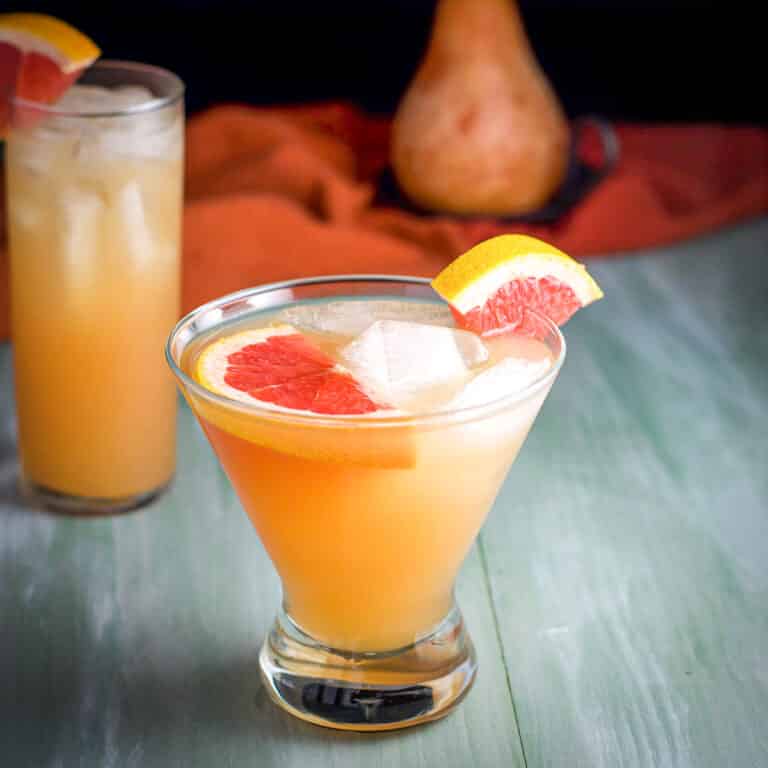 Square photo of the martini glass with the cocktail in it with one grapefruit slice floating and one on the side of the glass
