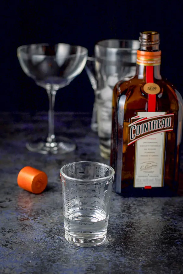 Cointreau measured out for the cosmo with the bottle in the background