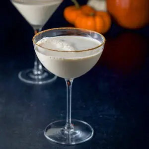 Cinnamon sugar lined martini glasses with the pumpkin martini. There are pumpkins in the background - square