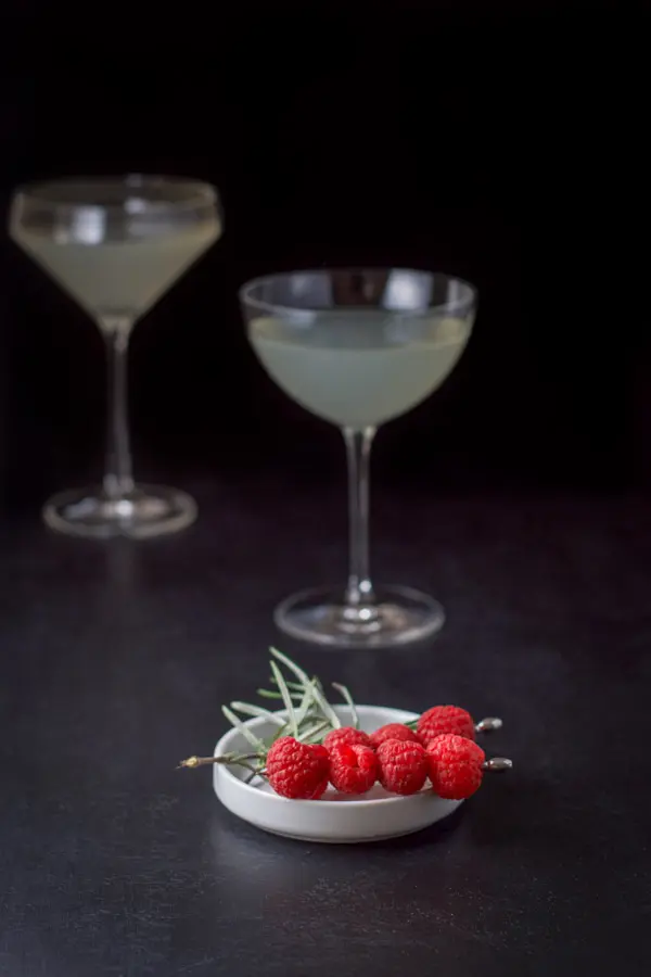 Raspberries on skewers and rosemary on a plate for garnish for the cocktail