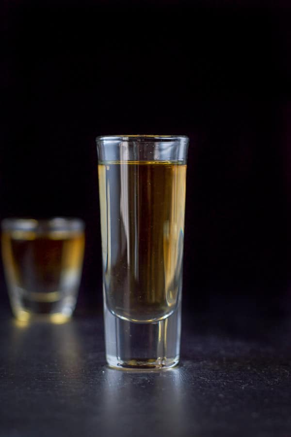 Vertical shot of the amber shot. The tall glass in front of the short glass