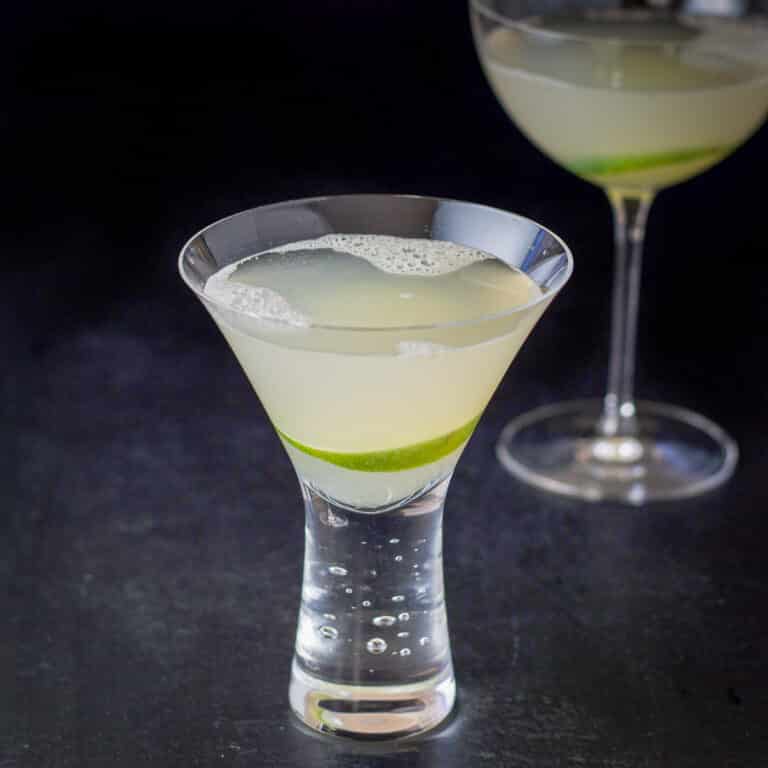 The short bubble glass filled with the lime cocktail with a lime wheel in it - square