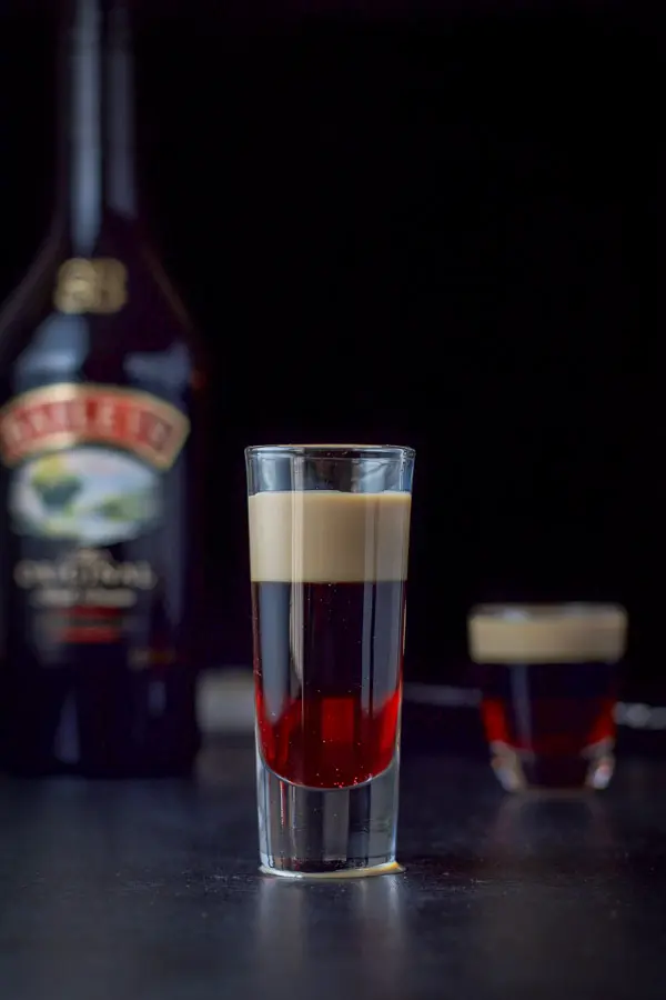 Baileys layered into the glasses with the bottle in the background