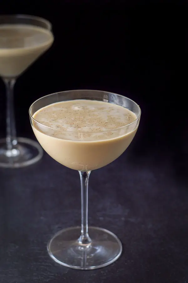 Closer view of the chocolate cocktail in the curved glass. The drink is garnished with ground nutmeg