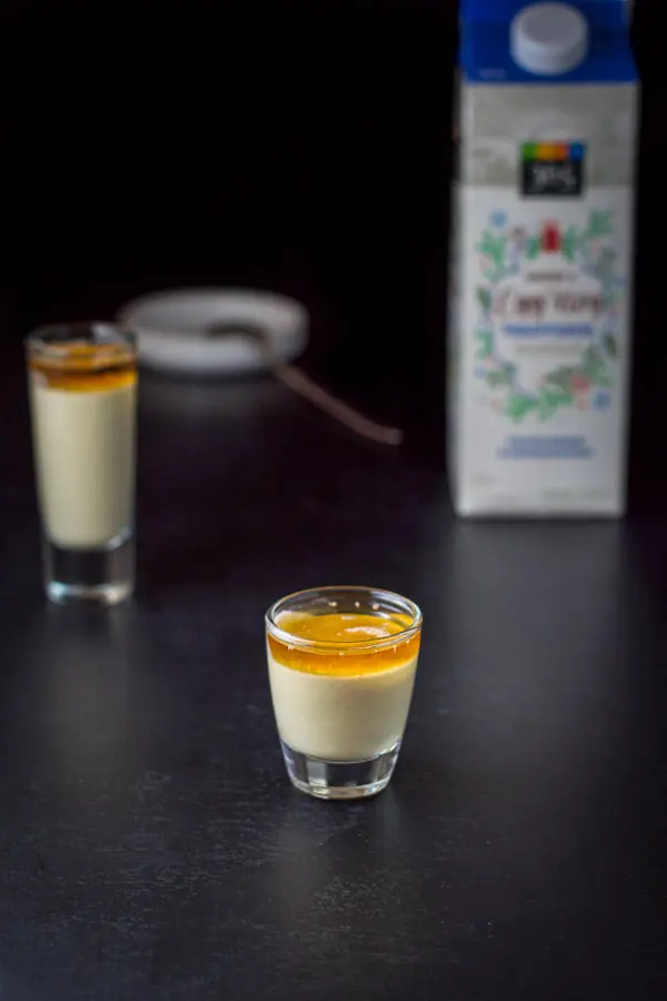 The eggnog poured into the glass switching places with the brandy, there is an eggnog carton in the background