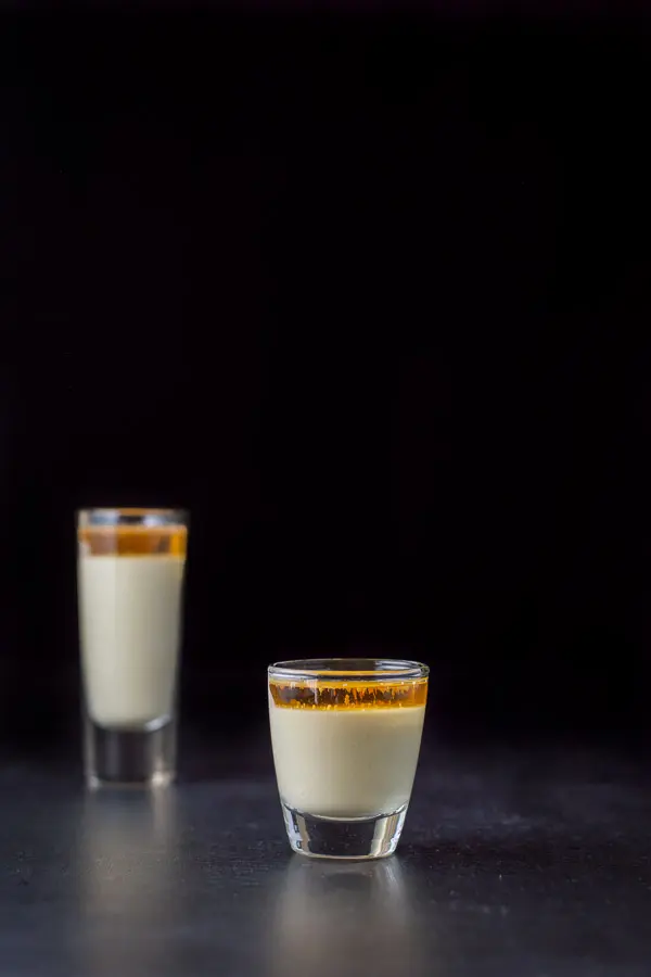 Vertical view of the creamy shot with the small glass in front and the tall one in back