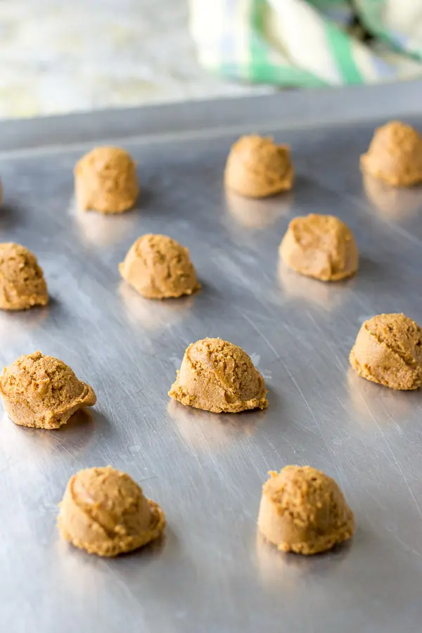 Balls of cookie dough on a cookie sheet ready to go in the oven
