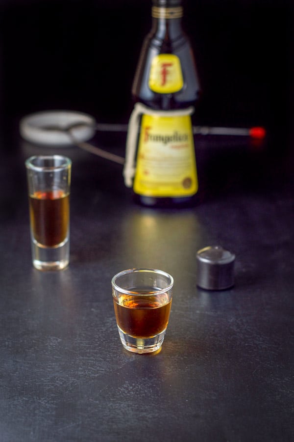 Frangelico layered into the glasses with the bottle and cocktail spoon in the background