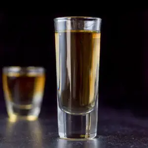 Tall glass filled with the amber shot - square