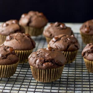 A wire rack with chocolate muffins cooling