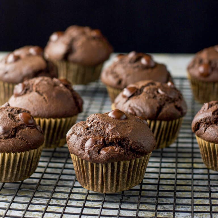 A wire rack with chocolate muffins cooling