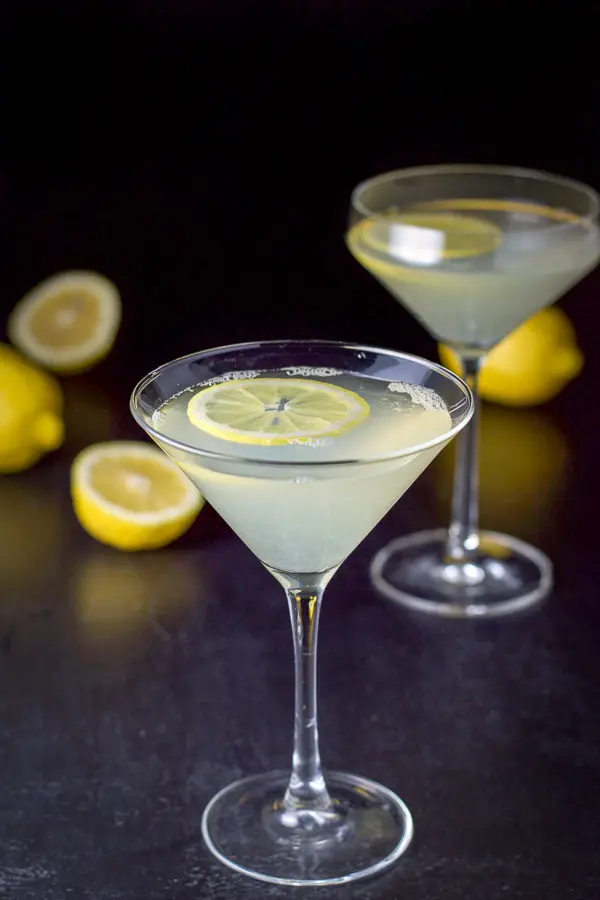 Lemon wheels floating in two martini glasses filled with the lemon cocktail