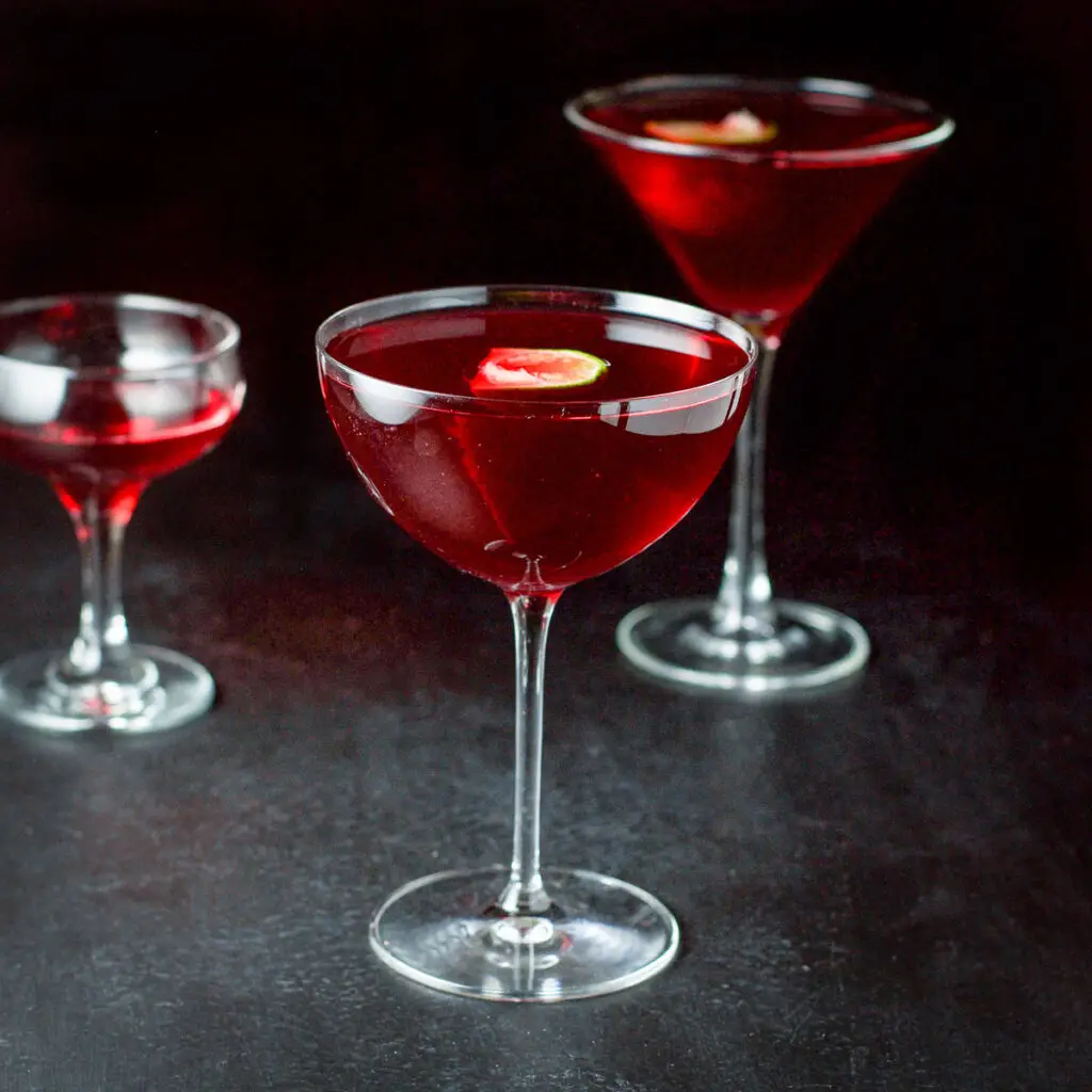 Three glasses filled with a red cocktail - square