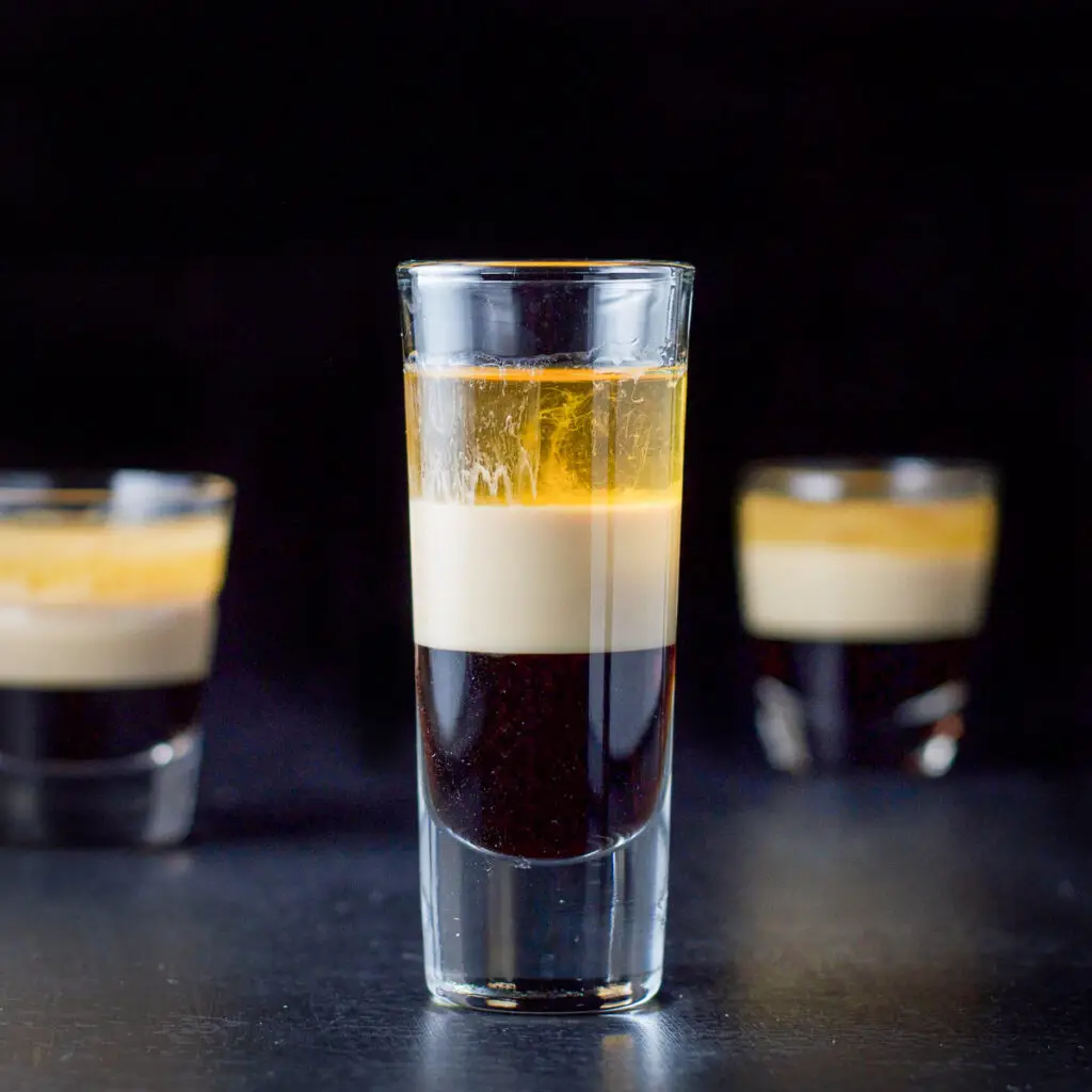 Square photo of the three layered shot with the tall glass in front and the two smaller glasses in the background