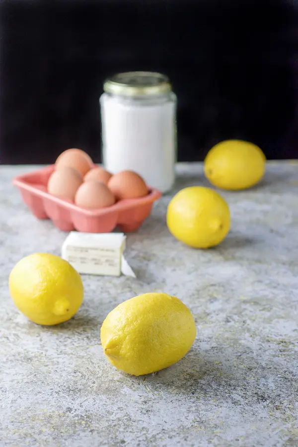 Lemons, eggs, butter and sugar on a grey table