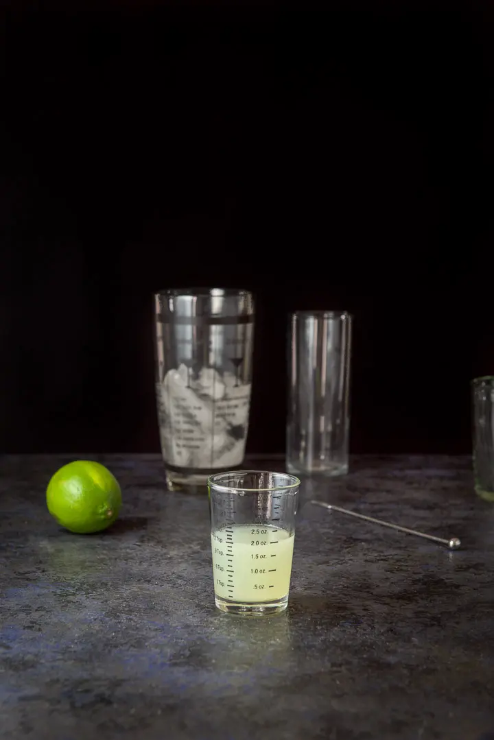 Lime measured out with a lime, shaker and glassware in the background