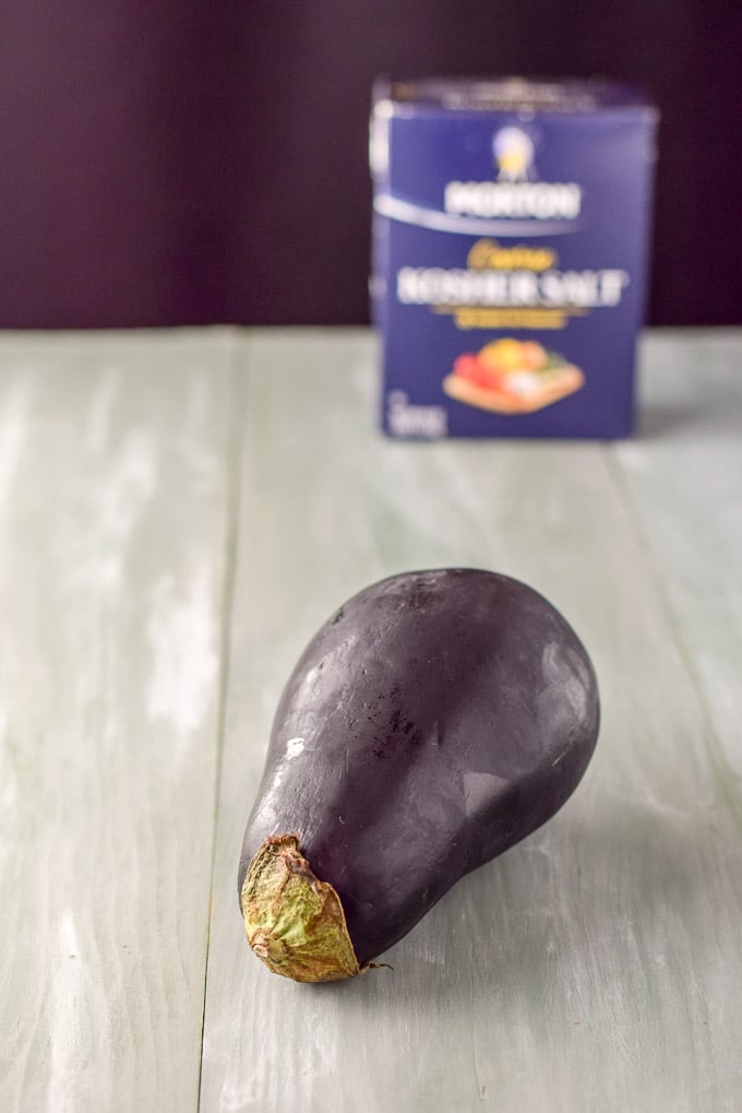 Eggplant and salt on a green table