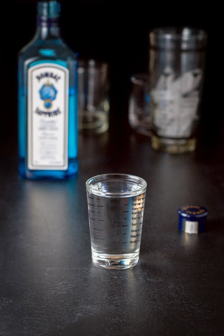 Gin measured out with the bottle and shaker in the background