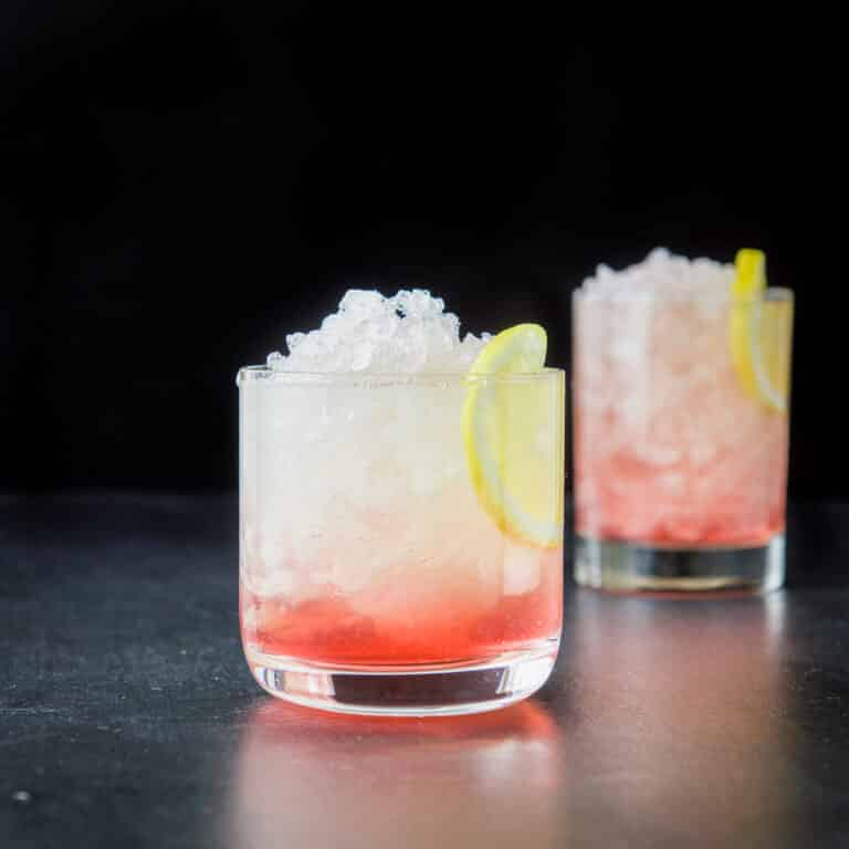 Shorter glass filled with the bramble cocktail in vertical view - square