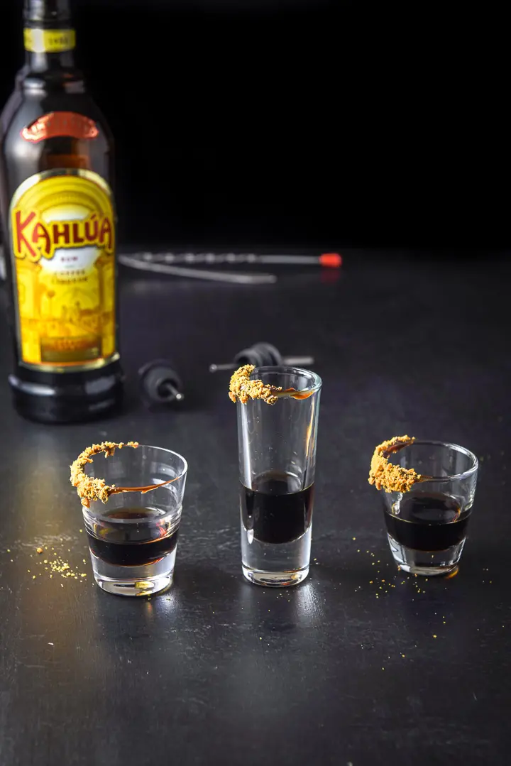 Kahlua poured into the three glasses with the bottle in the background