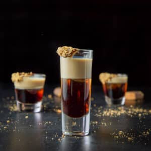 Tall glass filled with the layered candy bar shot - square