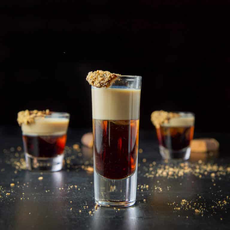 Tall glass filled with the layered candy bar shot - square