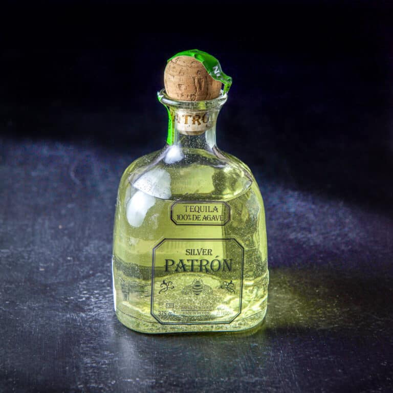 A bottle of infused tequila all green from the jalapeño - square