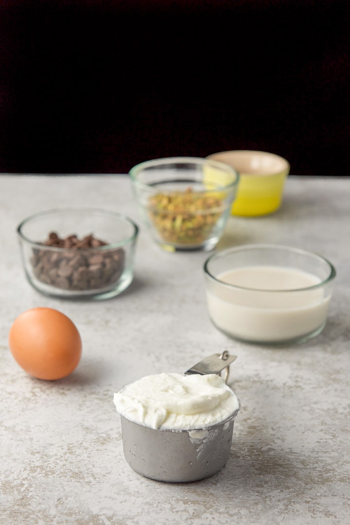 Yogurt, milk, eggs, chocolate chips and pistachios on a table
