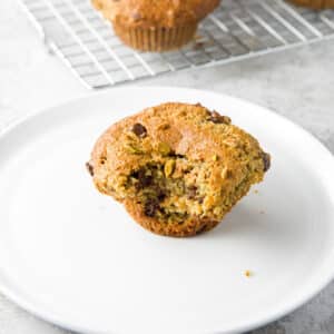 A plate with a muffin with a bite taken out of it
