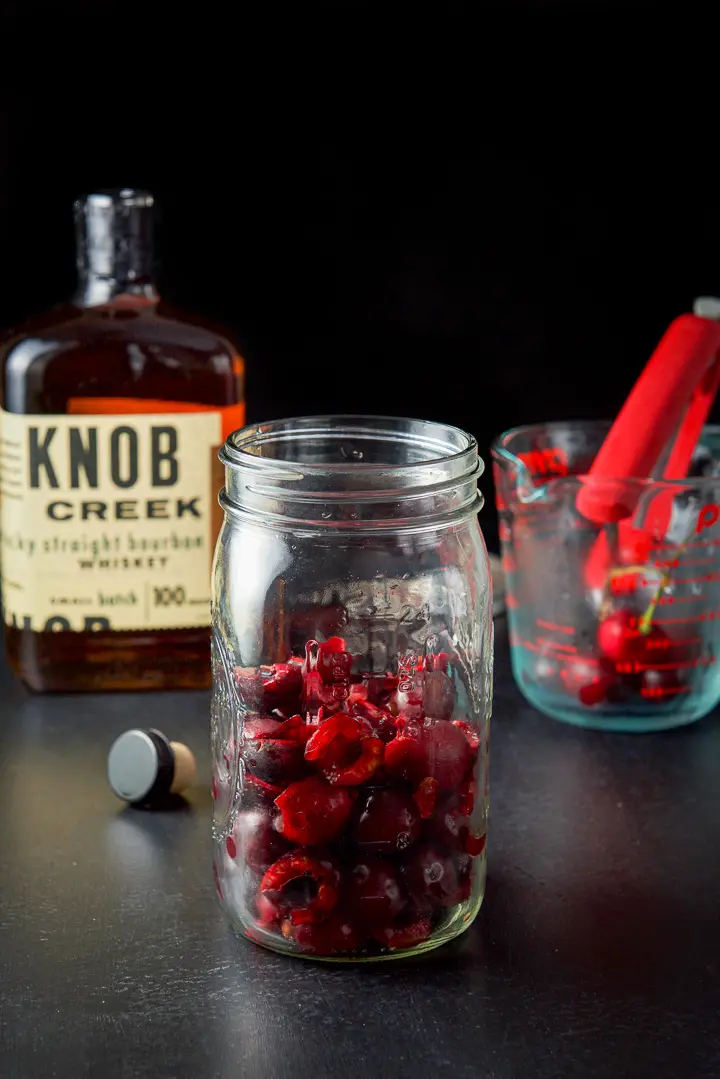 Pitted and halved cherries in a jar for the cherry bourbon