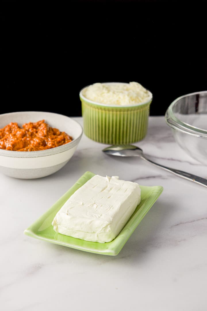 cream cheese, chili and mozzarella cheese on a table