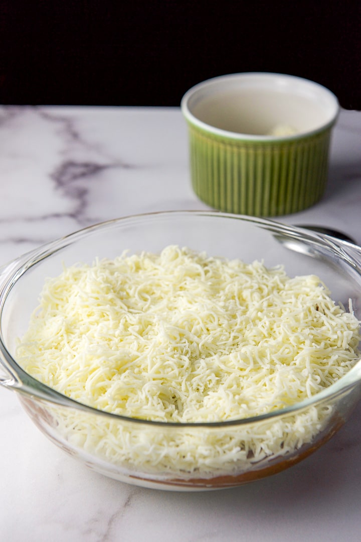 Mozzarella cheese sprinkled in the baking dish