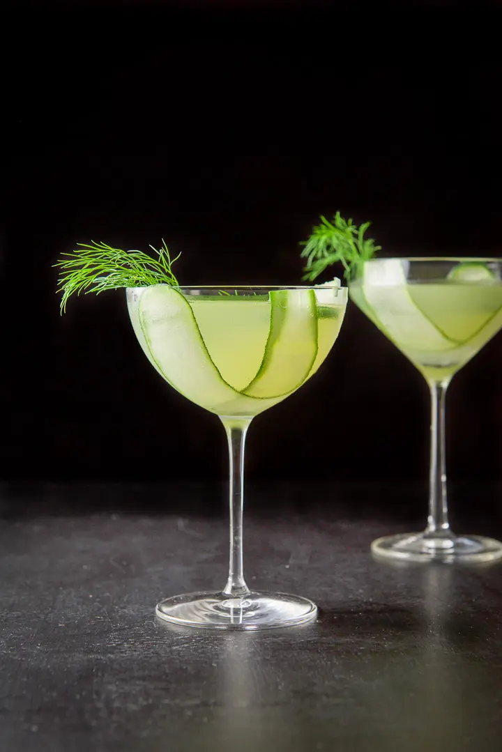 Vertical view of the bowl glass with cucumber and dill garnish in the martini