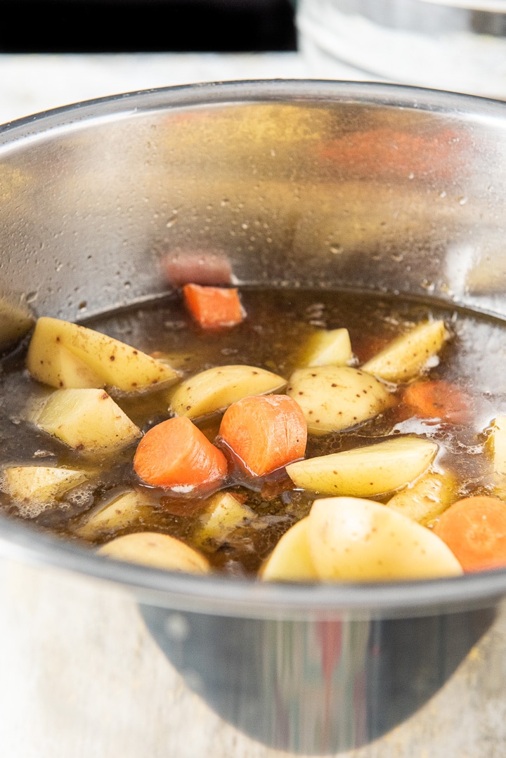 Raw carrots and potatoes in the instant pot with the beef