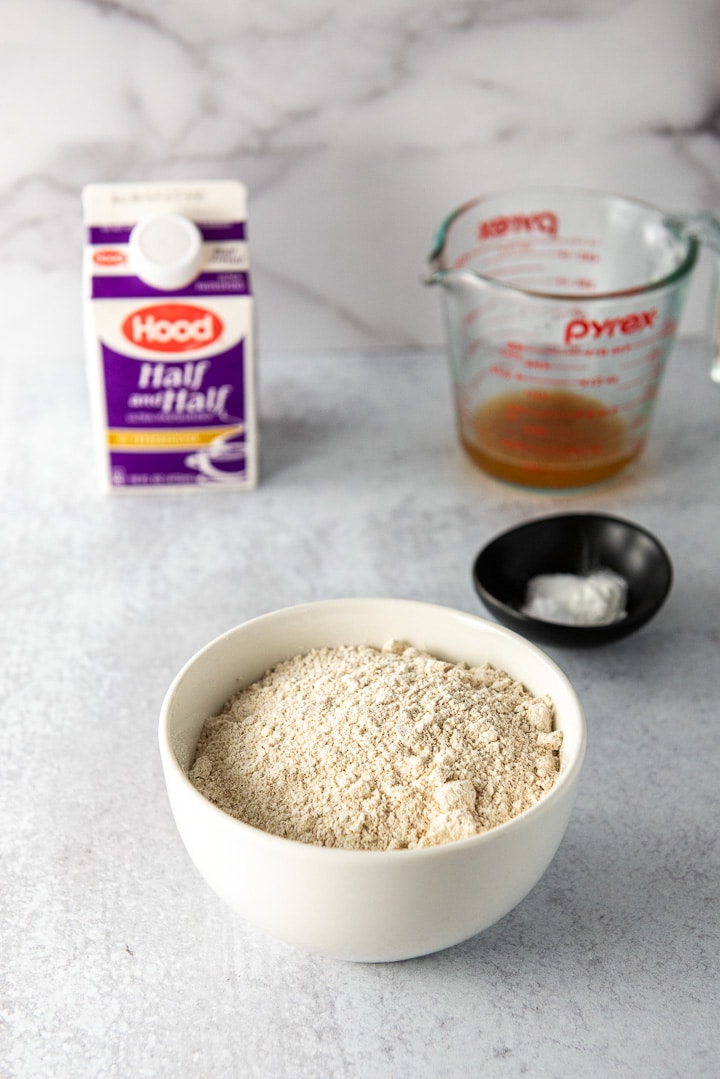 Flour, baking powder, salt, half & half and reduced apple cider on a table