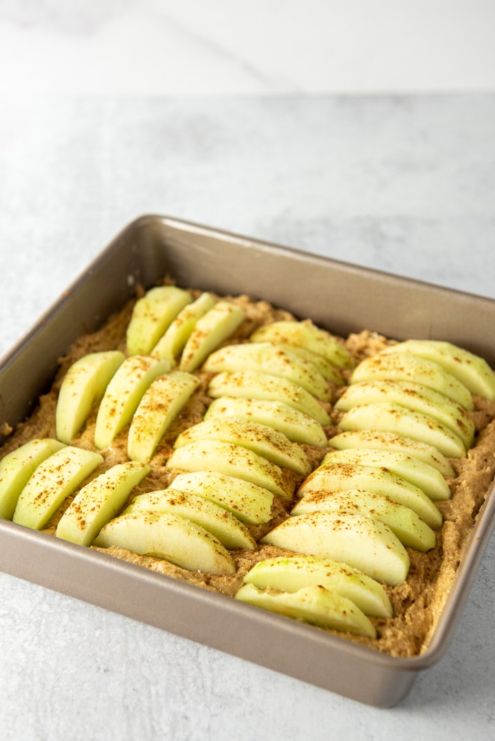 Sliced apples pushed in the batter and cinnamon and sugar sprinkled on top
