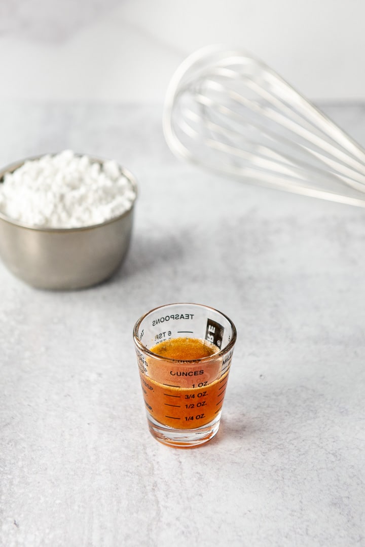 Reduced apple cider in a little measuring glass and confectioner's sugar for the glaze behind it