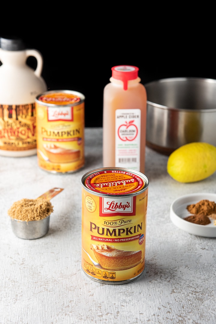 canned pumpkin, brown sugar, spices, lemon, apple cider and maple syrup on a table