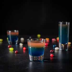 Square of the vertical view of the beveled glass in front of the two other glasses ad jelly beans on the table