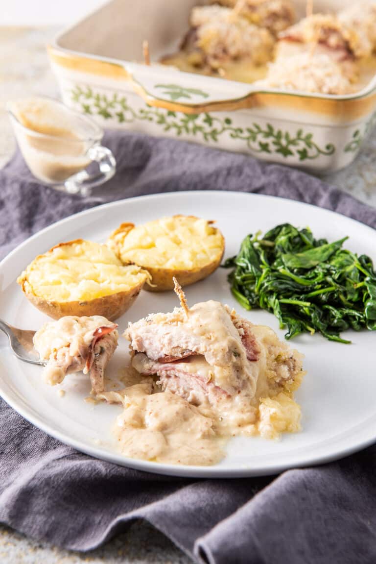 A forkful of the baked chicken cordon bleu on the plate