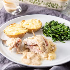 A forkful of baked cordon bleu on a plate - square