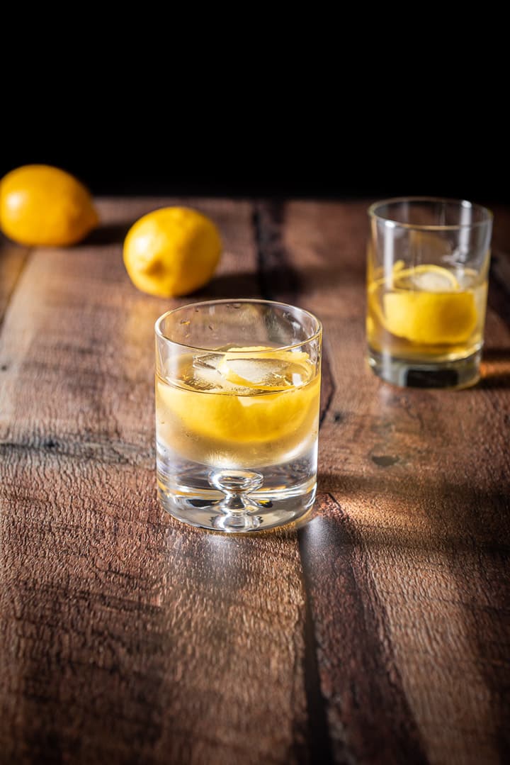 Two glasses of the cocktail with two lemons in the background