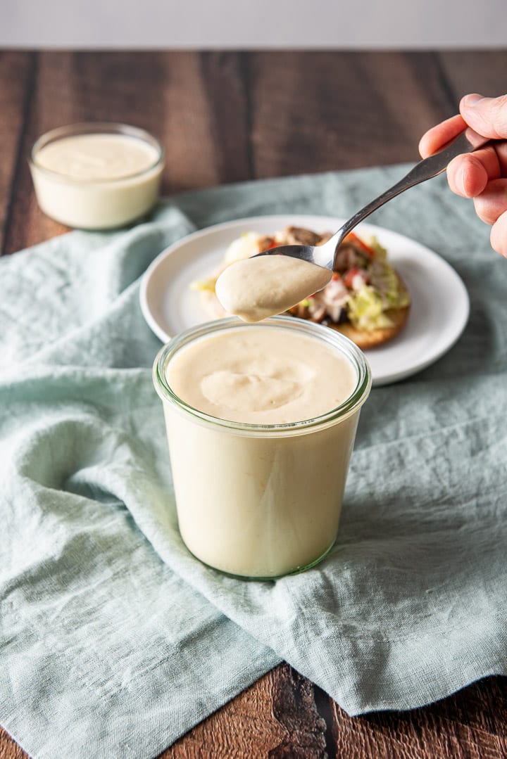 A spoonful of sauce held over the jar