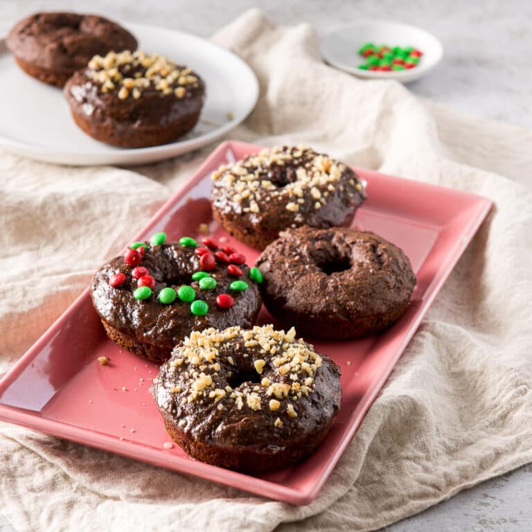 A pink plate of baked chocolate donuts - square