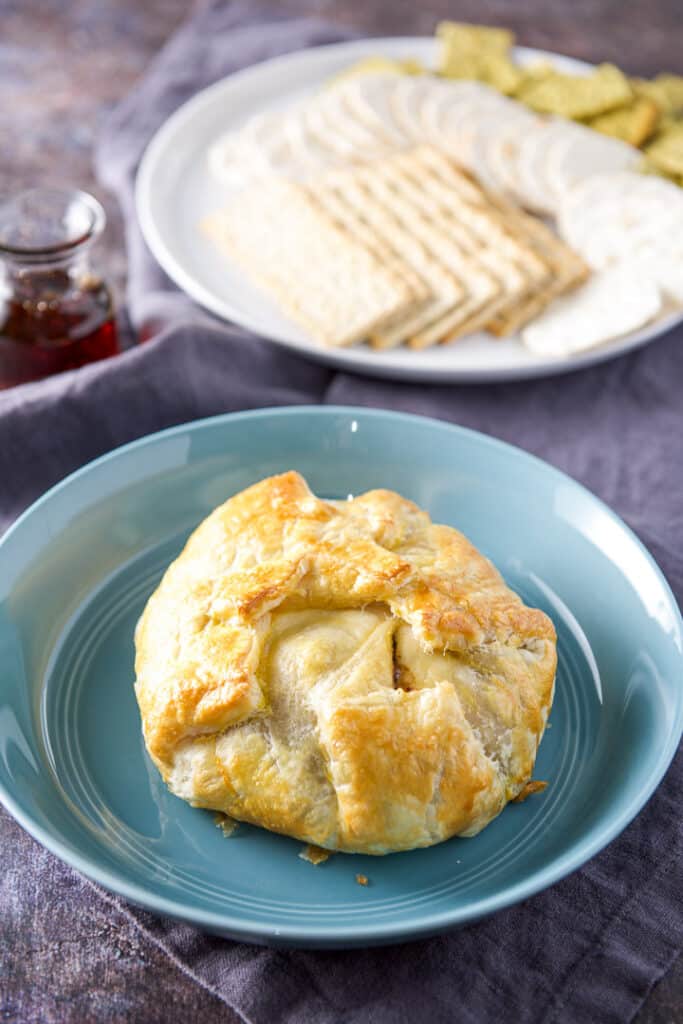 Filled puff pastry straight out of the oven with crackers and maple syrup in the background