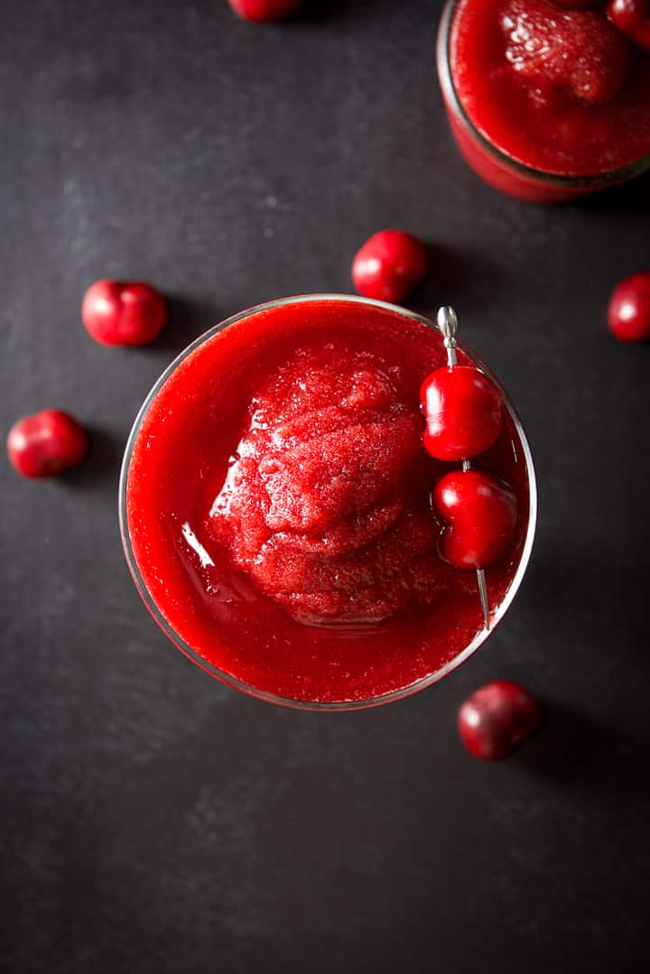 Overhead view of the cherry margarita in two glasses with cherries on the board