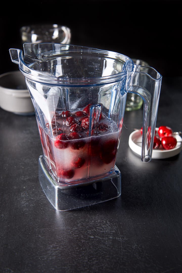All the ingredients plus the cherries in the blender and off to the side, some cherries on picks