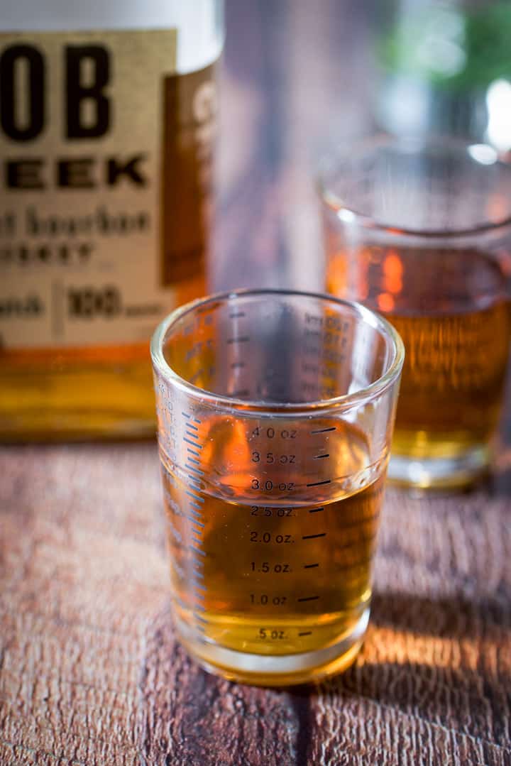 Bourbon measured out with the bottle in the background
